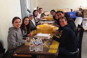 NHS members Daria Lasc, Kelsey Hampson, Ayah Kantari (left side-front to back), Katelyn Lowry, and Angel Menchaca (right side-front to back) helped cut and package straws at the Second Harvest Food Bank.