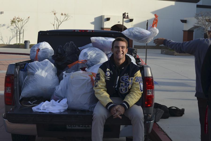 Jack Reisinger (12) works with members of the baseball team collecting bags of used clothing for the fundraiser.