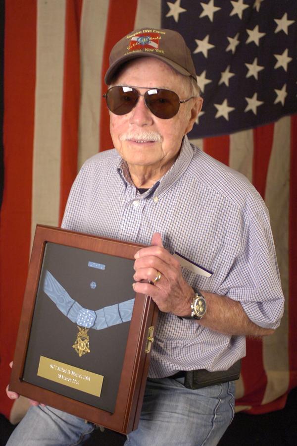 Retired campus supervisor, Bob Nietzel holds the Medal of Honor awarded to his cousin Alfred B. Nietzel.