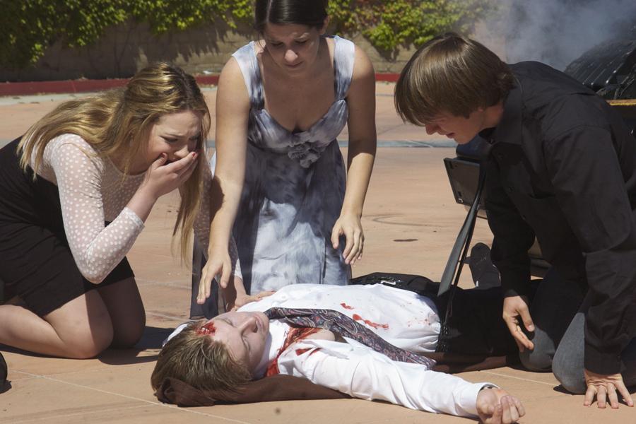 Madeleine Blomdahl, Brooke Morris, and Connor Hill surround Jacob Duhey and wait for the ambulance to come.