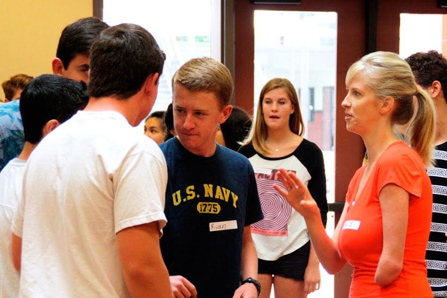 Link Crew adviser Kimberly Stanga works with the link crew leaders, teaching them how to properly introduce themselves to the freshmen at orientation. Ryan Brown (11) listens carefully and plans his introduction. Photo by Macy Drew