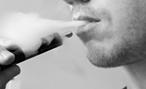 UP IN SMOKE: The photo above represents the rising popularity of e-cigarette (e-cig) users. New studies and surveys done by the Center for Disease Control explain the contents of the e-cigarette which contain compounds found in antifreeze and brake fluid. Along with the dramatically increasing number of users, specifically youth, the Food and Drug Association has not regulated many companies that produce e-cigs. Photo by Jon Williams.
