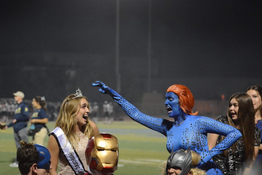 Mrs. Klingbeil, Sophomore and Senior English teacher, portrays super villain Mystique in this years Halftime Show and pretends to snatch Queen Brittany Hills (12) crown.  Her makeup was done by Celina Gigliello (12) of the Drama department.
