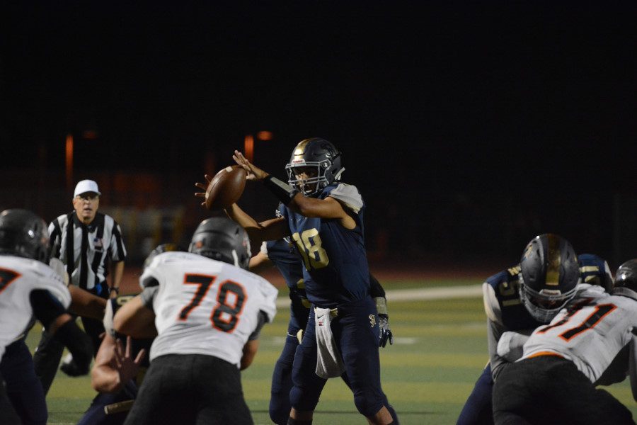QB Matt Rodriguez (12) attempts to complete a play called by Coach Flowers, SJHHSs coach for the past 5 years.  