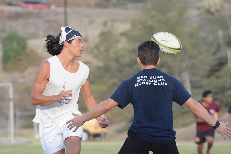 Team member, Danny Olswang, completes a pass before darting around a defender at practice. The team is preparing for their first game, a friendly scrimmage, against Dana and San Clemente December 3rd