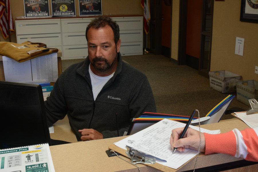 Administration Office Secretary, Manny Romero, keeps a watchful eye over who signs in to visit the campus. Visitors must sign their name on the sheet and receive a visitor sticker in order to comply with school policy.