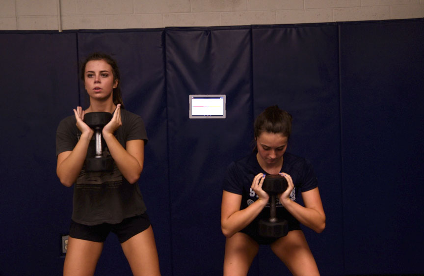 Makayla Walders and Nicole Strauch log in to their assigned tablet and start their workout with some goblet squats while training with the new Alpha Athletics Program. 
