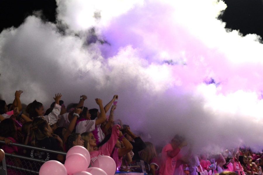 Fans in the student section dance as carbon gas is blasted into the air during the pink out game against Mission Viejo. ASB continues to experiment with music and other effects to rally the student section.