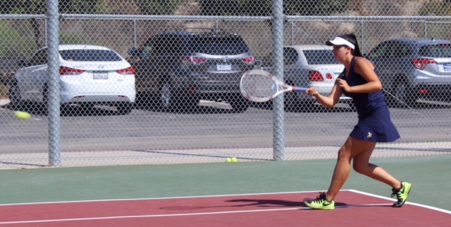 Varsity+captain+Kelley+Green+%2812%29+hits+a+forehand+in+practice.+The+girls+hit+between+50-100+forehands+a+day+in+order+to+hone+their+skills+for+matches.+They+would+also+practice+backhands%2C+volleys%2C+overheads%2C+and+serves.+Green+played+line+one+doubles+with+her+co-captain%2C+senior+Reese+Thomas.