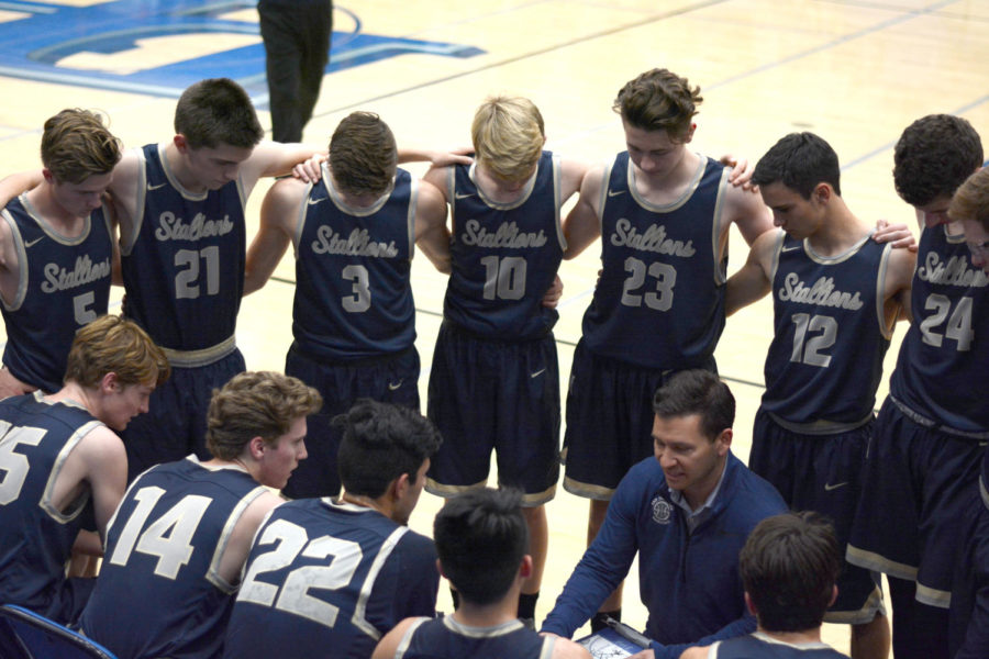 The+boys+Varsity+basketball+team+huddles+before+their+game+against+Dana+Hills.+The+Stallions+won+49-45.