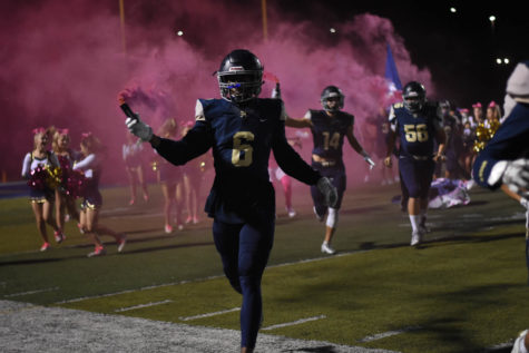 Darius Jackson, 6, carries a smoke bomb during the last home football game against Aliso Niguel High School.