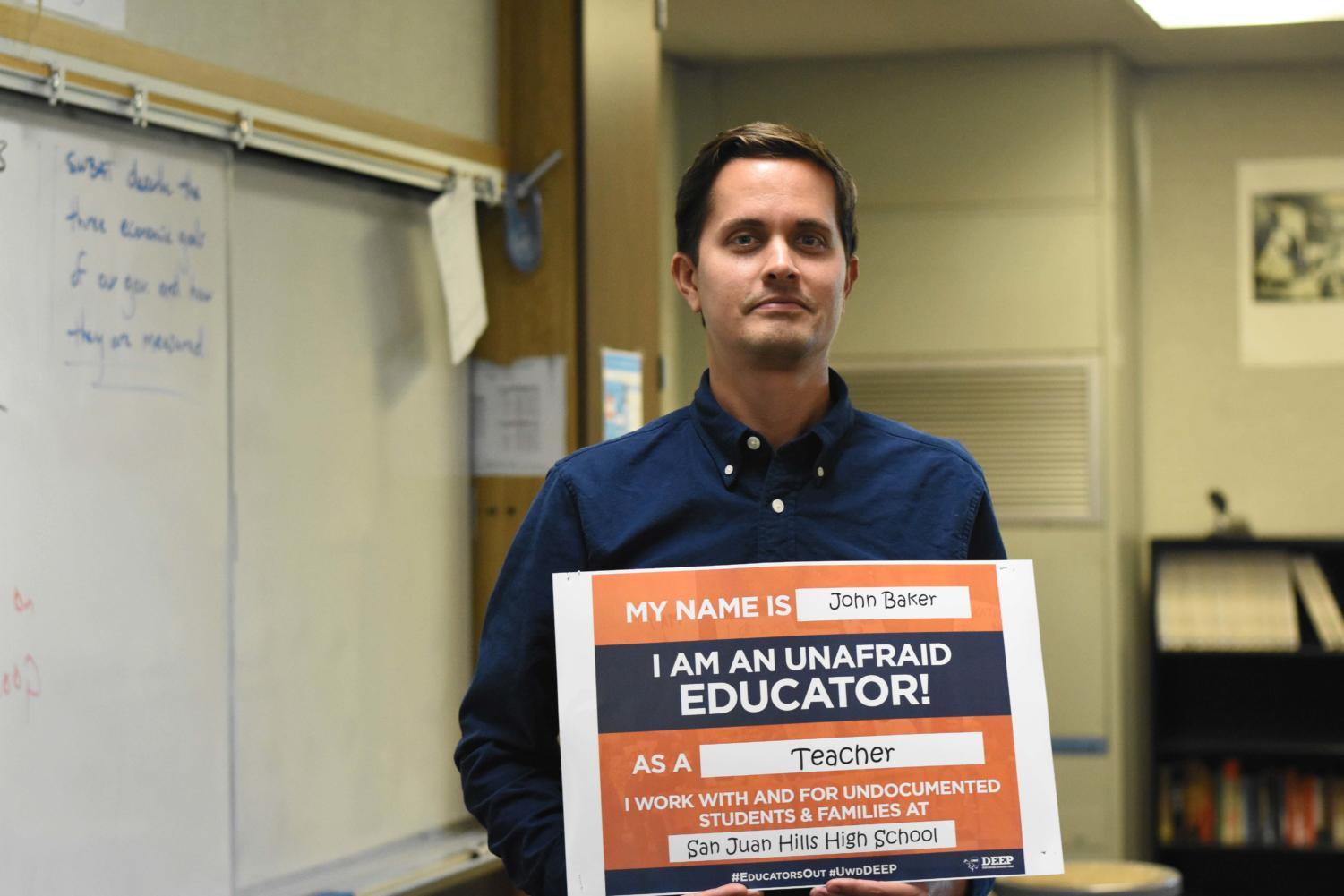 History tecaher, John Baker, holds one of the many posters that are all around teacher’s rooms at SJHHS. By stating that the teachers are unafraid to educate undocumented students, it is a hope that DACA recipients will feel comfortable and accepted at SJHHS.