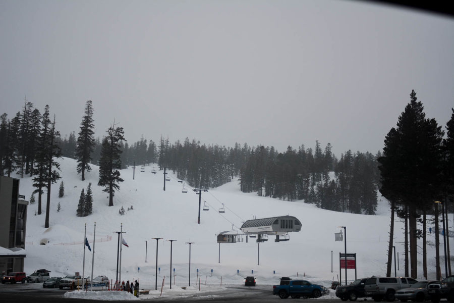 Snow falls on the slopes of Mammoth Mountain as snowboarders and skiers make their way down the mountain.