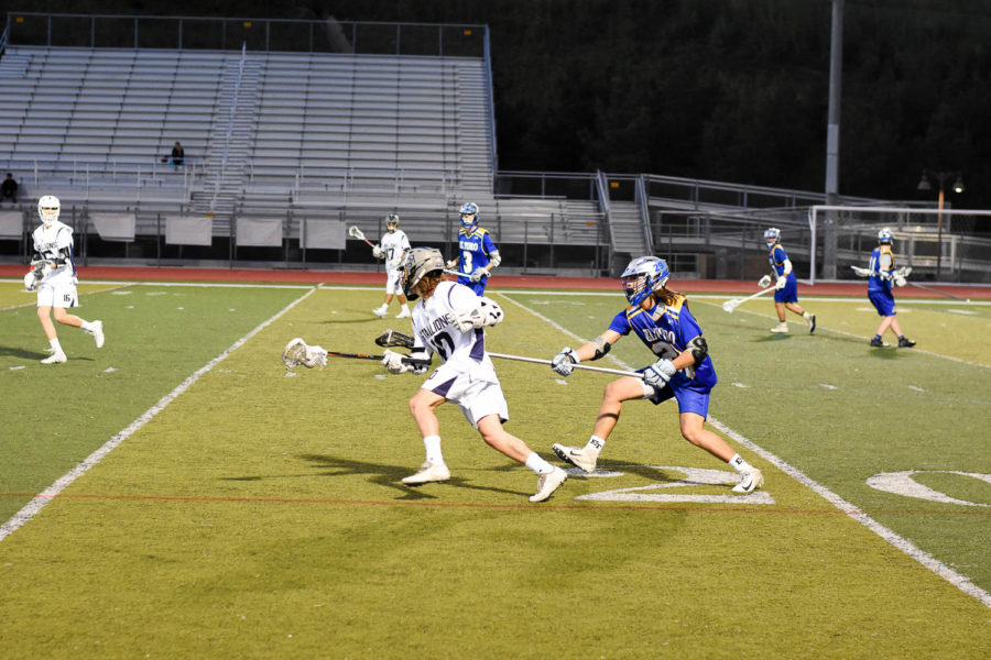 Varsity Captain and Junior Josh Mastropaolo attempts to get the ball away from their goal and make an attempt to score in the second quarter. The varsity boys lacrosse team would eventually lose in overtime against El Toro, 13-12.