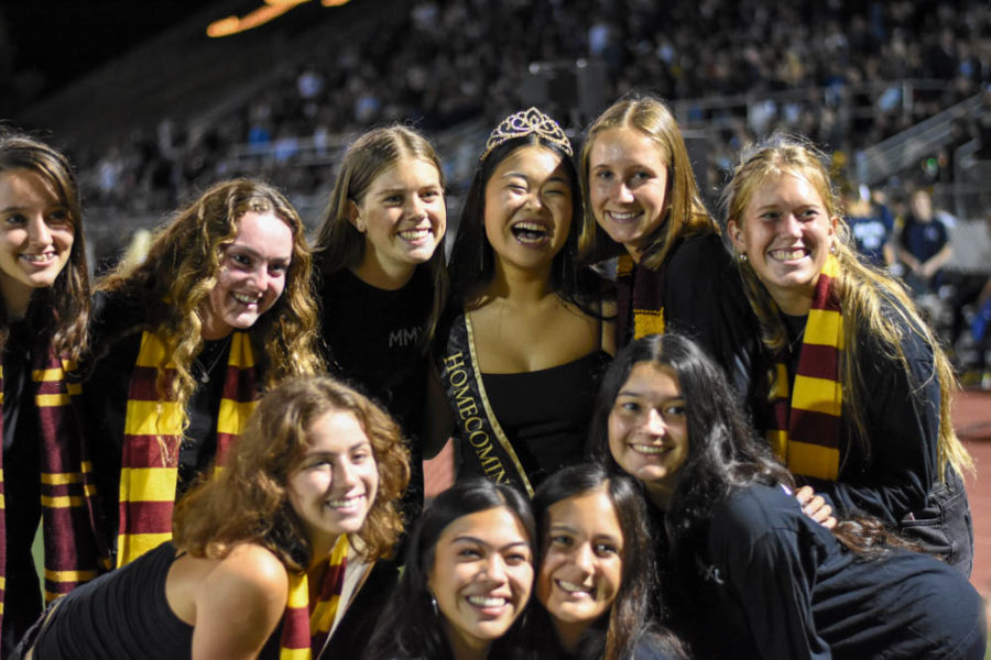 Maddie Yi, 2019’s Homecoming Queen, poses for a photo surrounded by friends. After Harry Potter and friends got the Homecoming results back from Draco Malfoy, cheers and screams of joy filled the stands as the names were announced.