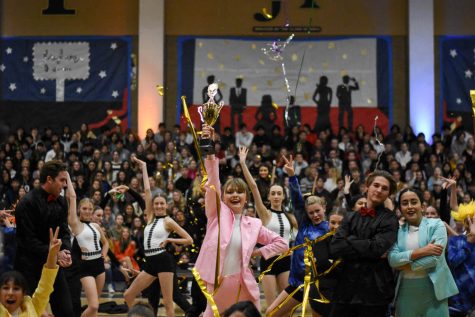 Noelle Hansen (12) acts as Taylor Swift as she wins a Grammy in the winter formal pep rally. Alina Apostolache (12) and Dylan Curialle (12) pose behind her.