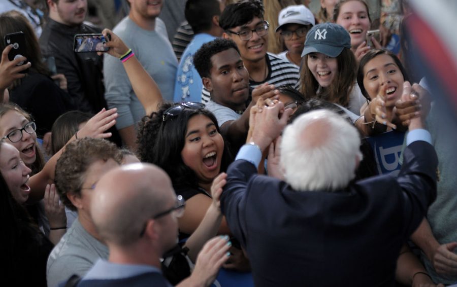Feel the Bern: Senator Bernie Sanders greets a group of young people at a September rally at the University of Chapel Hill. In recent weeks, he has become the clear frontrunner for the Democratic nomination, thanks in part to his overwhelming support among young voters. 