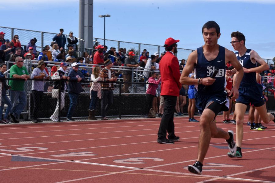 Joe Scgounztos (12) recieves the baton from Hayden Parker (10) to run his leg of the 4x1600 meter relay at the Griffin Relays Invatational. Despite track season being cut short this year, Joe was able to have his biggest accomplishment this past January at the Irvine Half Marathon. 
