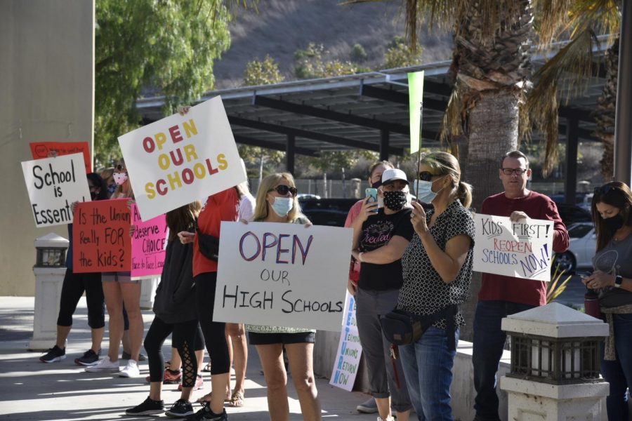 Parents opposed to an extension of online learning for high school students gathered outside the district office on Tuesday.