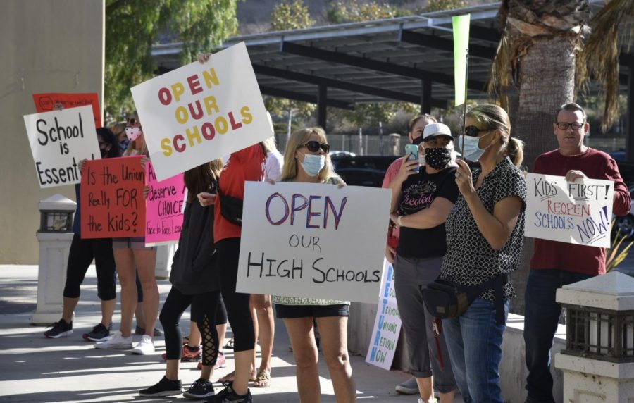 Parents opposed to an extension of online learning for high school students gathered outside the district office on Tuesday.