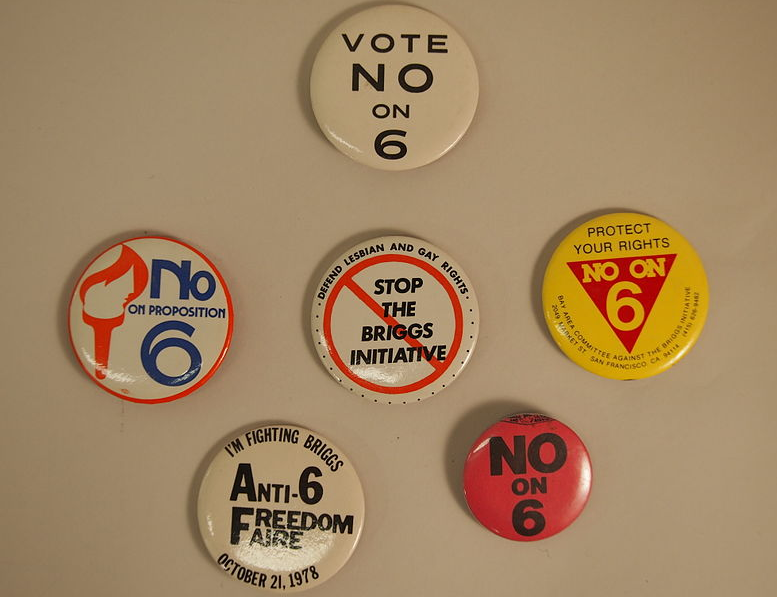 This image captures buttons used during the campaign against the Briggs Initiative, otherwise known as Prop 6. This sought to ban gay and lesbian teachers from working in public schools. 