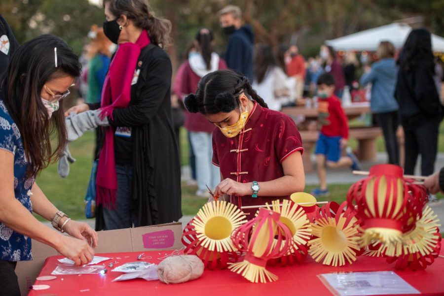 A child carves designs into lanterns and cuts string at the festival.