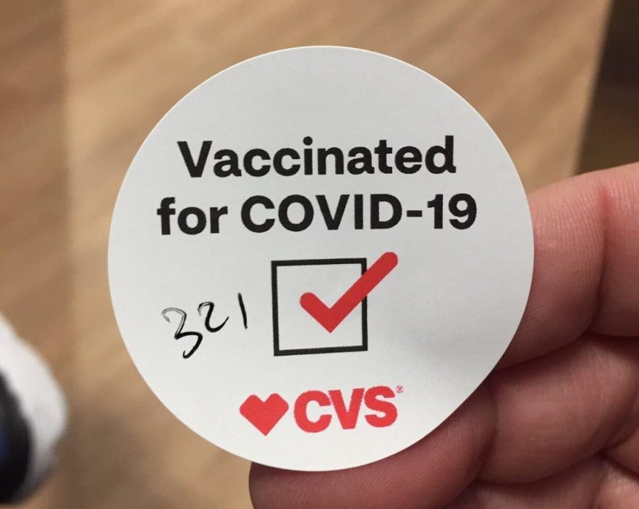 After receiving a vaccination at CVS, patients are required to remain 15 minutes to see if an adverse reaction occurs. They are given stickers with the time they are allowed to leave written on them.