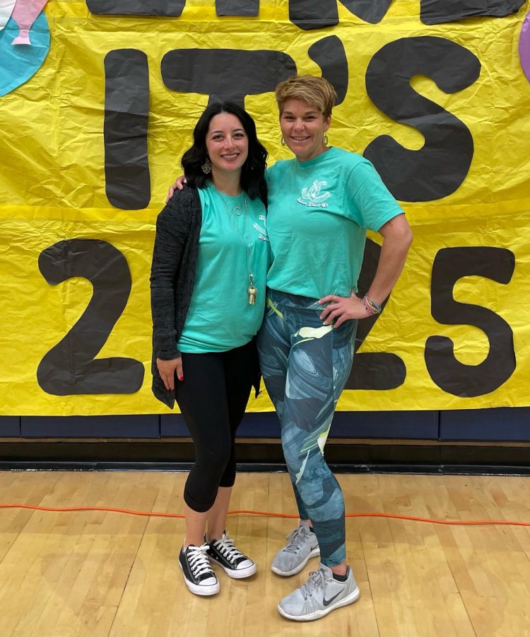 New Stallion Start-Up advisors, Lintz and Hansen, smile for a photo in front of a poster made by ASB, welcoming students to the freshman orientation.