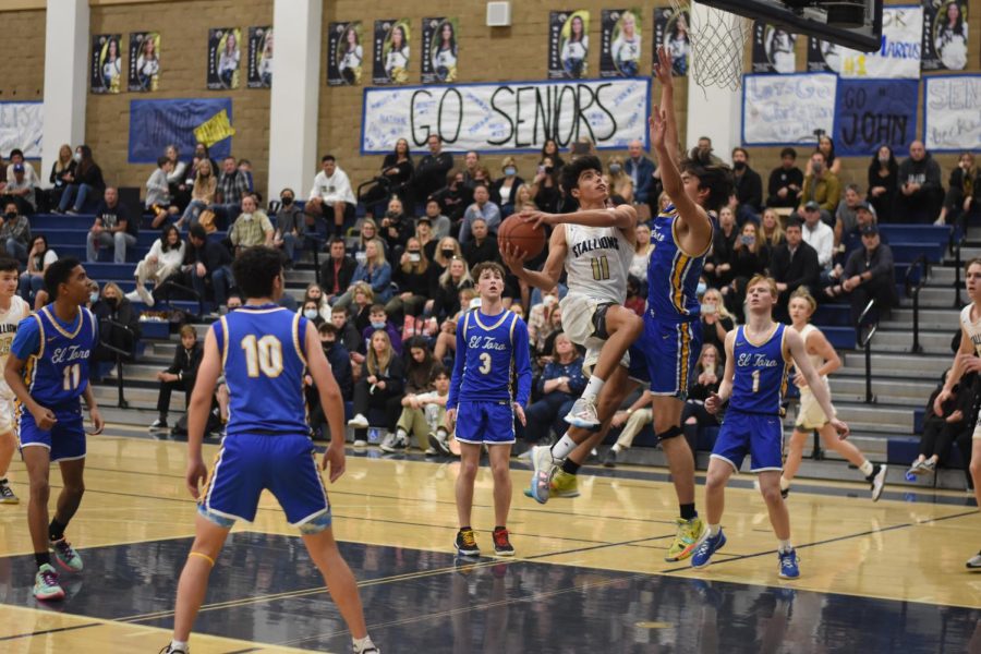 Varsity team captain, Mark Reichner (12), scores a point in their January 28 game against El Toro. San Juan won 70-51, in an impressive senior night. This win followed a streak of victories for the varsity boys basketball team, who have been unstoppable, clinching the Sea View League Championship.