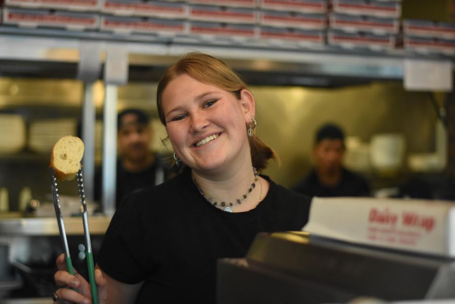 Student+worker+at+Joe%E2%80%99s+Italian+Kitchen%2C+Emma+Gibson+%2811%29%2C+smiles+as+she+enjoys+serving+customers.+Gibson+loves+making+invaluable+connections+with+her+fellow+student+coworkers.+