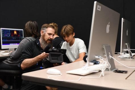 Video Production and Broadcast Journalism teacher, Jason Zuidema, shows Maxim Dubrovsky (9) the parts of a video camera.