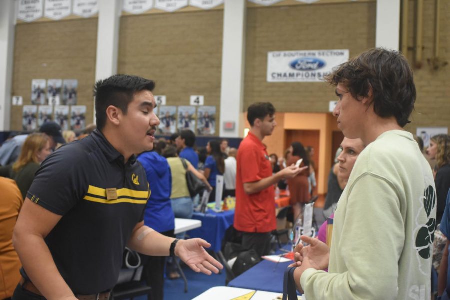 A Cal Berkeley representative speaks to Jack Perez (12) about which students best represent their university. The CUSD college fair took place on October 3rd at San Juan Hills High School and consisted of booths from over 100 colleges and universities.