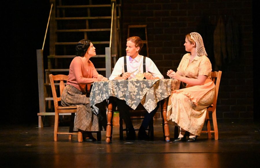 Grace Freyer talks with her mother, Mrs. Anna Freyer, portrayed by Ella Linn (12), and her boyfriend Tom Kreider, portrayed by Liam Herd (9). Her mother is upset at her quitting her job at the factory because her wage was much higher at the factory than anywhere else she could work. Tom supports her decision in leaving the factory and exploring her passion for art, but Grace dies before she can marry Tom.