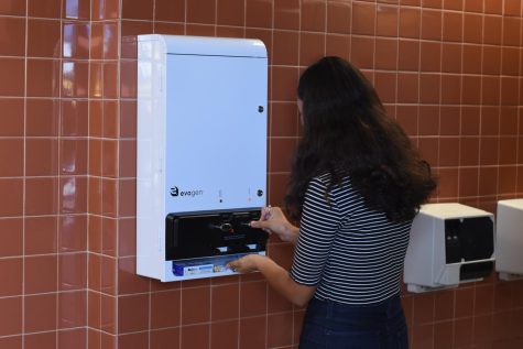 Domenica Pelsoso (10) tests new tampon dispensers installed in school restrooms after California law.