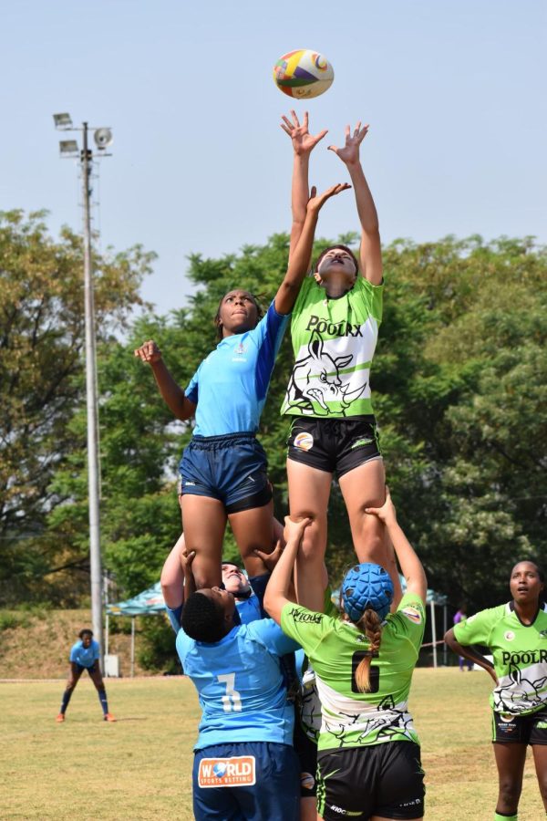 Rhino Rugby Academy player, Danica Snyder (11), competes against the Blue Bulls Rugby Union of Pretoria in South Africa. Snyder races to get the ball in a head-to-head rugby lineout.