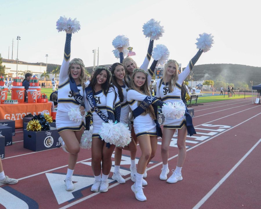 Varsity cheerleaders show their spirit, waving their pom poms and smiling together at the first home game of the season. The game was the cheerleaders’ Senior Night as well as a “Camo Out” honoring first responders.