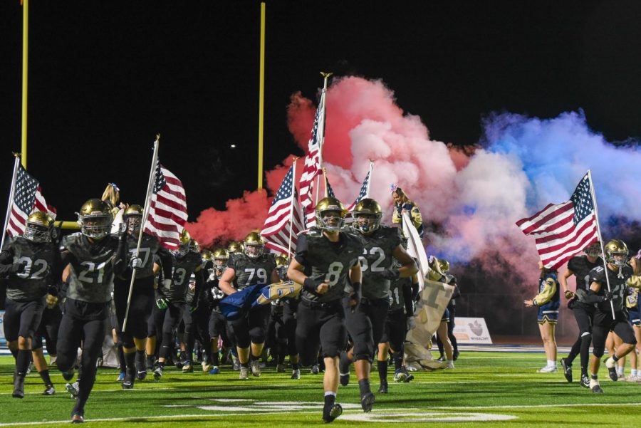 The Stallion football team charges onto the field followed by a trail of red, white, and blue smoke, kicking off their second game in the CIF Playoffs.
