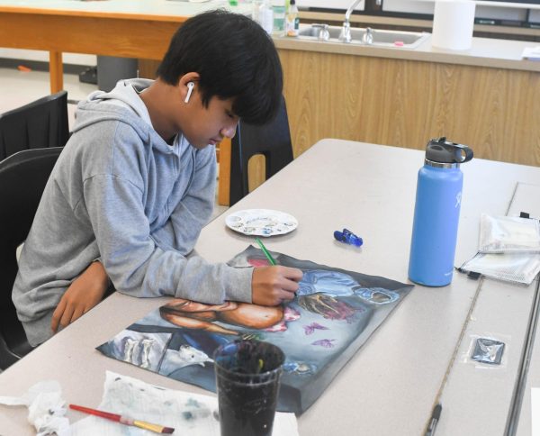 In Art class, peacefully painting, Tyler Vo (9) prepares to finish his artwork inspired by the game Operation to display it in the Clue Art Exhibit. Vo works with great serenity as he makes use of an array of colors, details, and dimensions in his painting.
