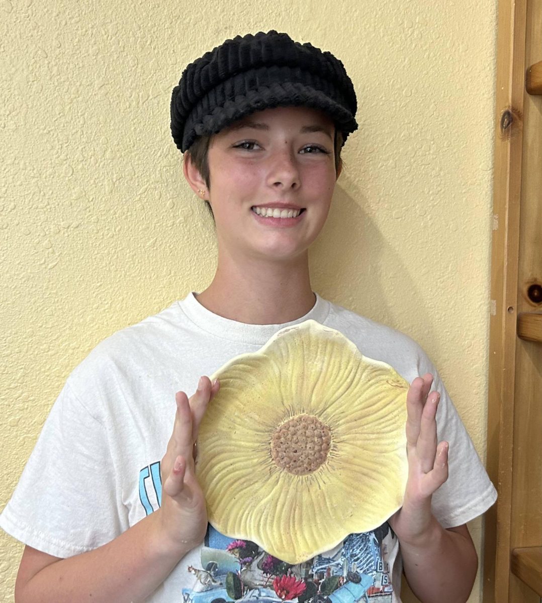 Sheela Zimels poses for a photo at The Hive in San Clemente, proud of her newest work of pottery; a sunflower plate that she made as a gift for her grandma. The plate took 4 hours to make, not including the week that the greenware will spend in the kiln being fired.