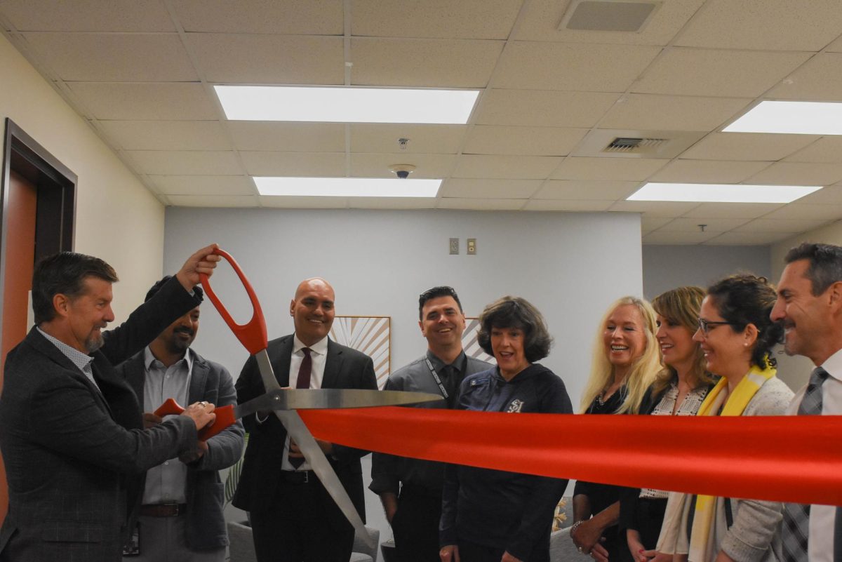 Cutting+the+ribbon+for+the+grand+opening+of+the+wellness+center%2C+Stuart+McClure%2C+Manoj+Mahindrakar%2C+Refugio+Gracian%2C+Christopher+Brown%2C+Judy+Bullocks%2C+Amy+Hanacek%2C+and+representatives+from+CHOC+Hospital%2C+join+together+to+celebrate+the+second+wellness+center+in+the+Capistrano+Unified+School+District.+Located+in+the+guidance+building%2C+students+can+come+in+to+take+a+break+and+practice+healthy+coping+habits+to+relax+with+pressures+and+anxiety.++