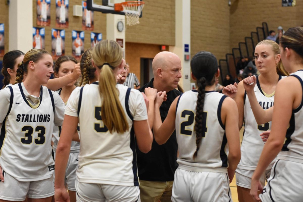 San Juan Hills girls basketball wins against San Clemente 66-48. The team huddles with Coach Paul Edwards in celebration before heading to the locker room for a game review.