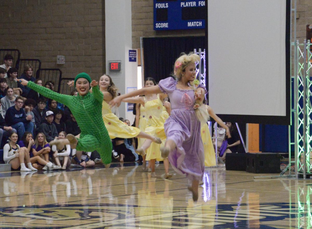 Pascal, Amelia Mui (11) and Rapunzel, Hannah McCabe (12) leap in the center of the Woodlands. This moment of the pep rally resembles the scene when Rapunzel frees her tower with her pet-sidekick chameleon.  