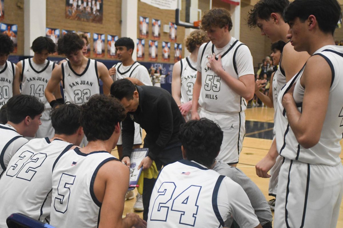 Varsity boys basketball team gathers around coach Jason Efstathiou to strategize the next play. San Juan Hills played a close game against Tesoro and came home with the win on senior night, beating them 65-57. 
