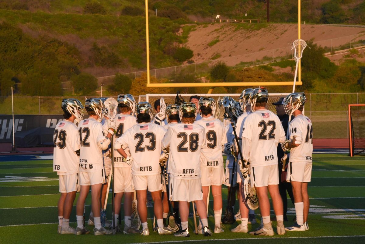 With the end of the first quarter of Boys Lacrosse Senior Night, senior students huddle with their team for one of the final times.The Stallions played the Dana Hill Dolphins and won the game with a score of 17-1