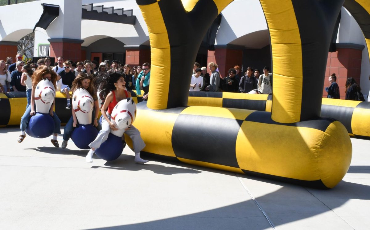 Sophie Haghighi (11) leads in an inflatable horse race. All week during break, each grade competes against each other in various events to gain points for Clash of Classes.