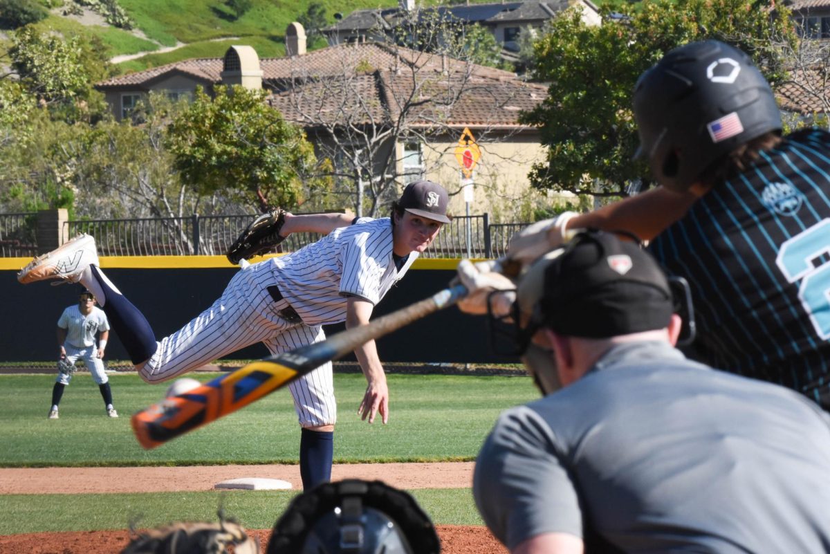 Pitcher+Drew+Nelson+%2811%29+delivers+the+ball+to+home+plate+towards+the+Aliso+Niguel+high+school+batter.+It+was+a+competitive+and+close+game%2C+Aliso+went+on+to+win+against+SJHHS+4-2.+