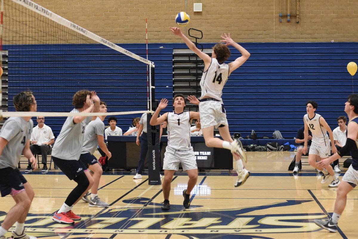Drew Presser (11) sets the ball as Riley Stone (10) prepares to strike the ball in their White Out game against Trabuco Hills. 
