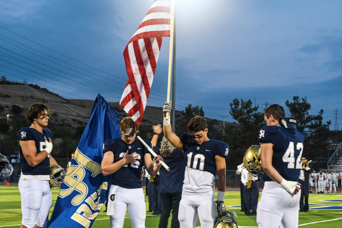 With hands over their hearts, Gavin Blum (12), Trey Young (12), Jake Vuoso (12), and Greg Blomdahl (12) show respect for their country. 
