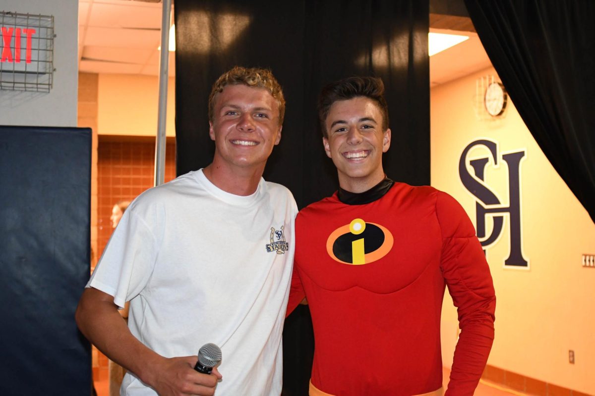 Proudly posing after their dynamic performance, pep rally MC’s Chase Walburger (12) and Zack Smith (12) show the student body how to properly RFTB. Smith shocked the crowd after quickly changing into a Mr. Incredible costume in order to reveal the 2024-2025 Homecoming theme: The Incredibles. 
