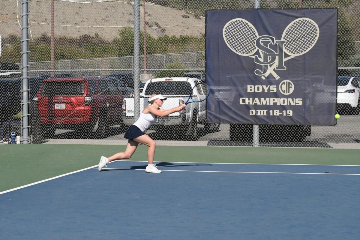 Taylor McDonald (12) lunges for the ball during the SJHHS match against JSerra. McDonald and her doubles partner, Sophia Roldan (11), won 6-4. 